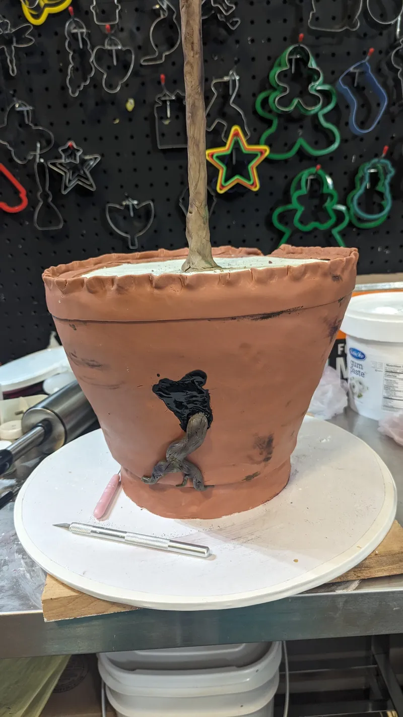Cake shaped like a terracotta flowerpot with a silhouette design