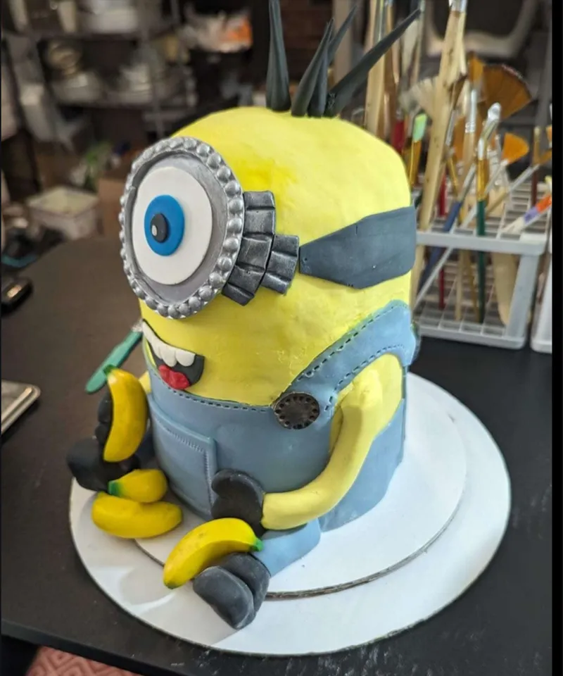 Sculpted fondant Minion cake holding a banana