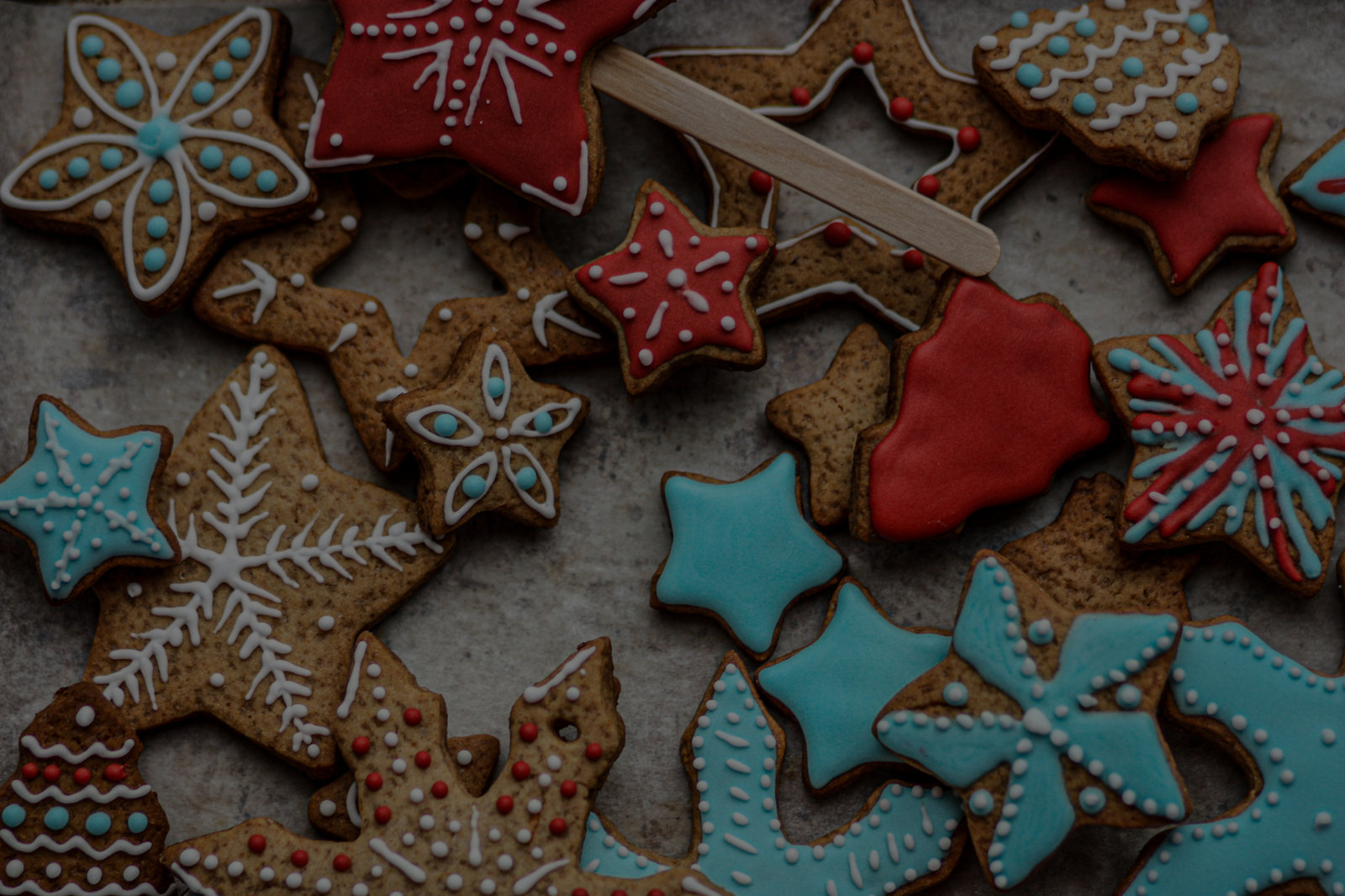 Holiday cookies with red, teal and white royal icing stars and snowflakes