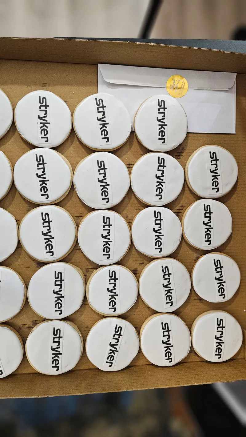 Round white cookies piped with a company logo, arranged in a box