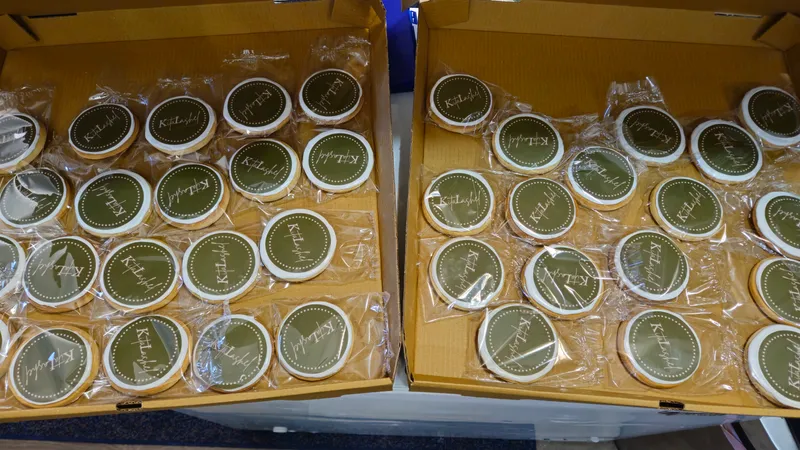 Rows of individually wrapped round logo cookies in boxes